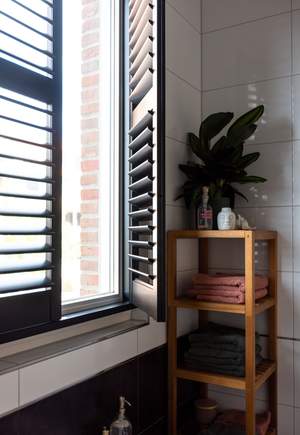 raamdecoratie badkamer: zwarte imitatiehouten shutters badkamer
