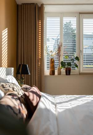 Shutters met planten tegen inkijk in de slaapkamer